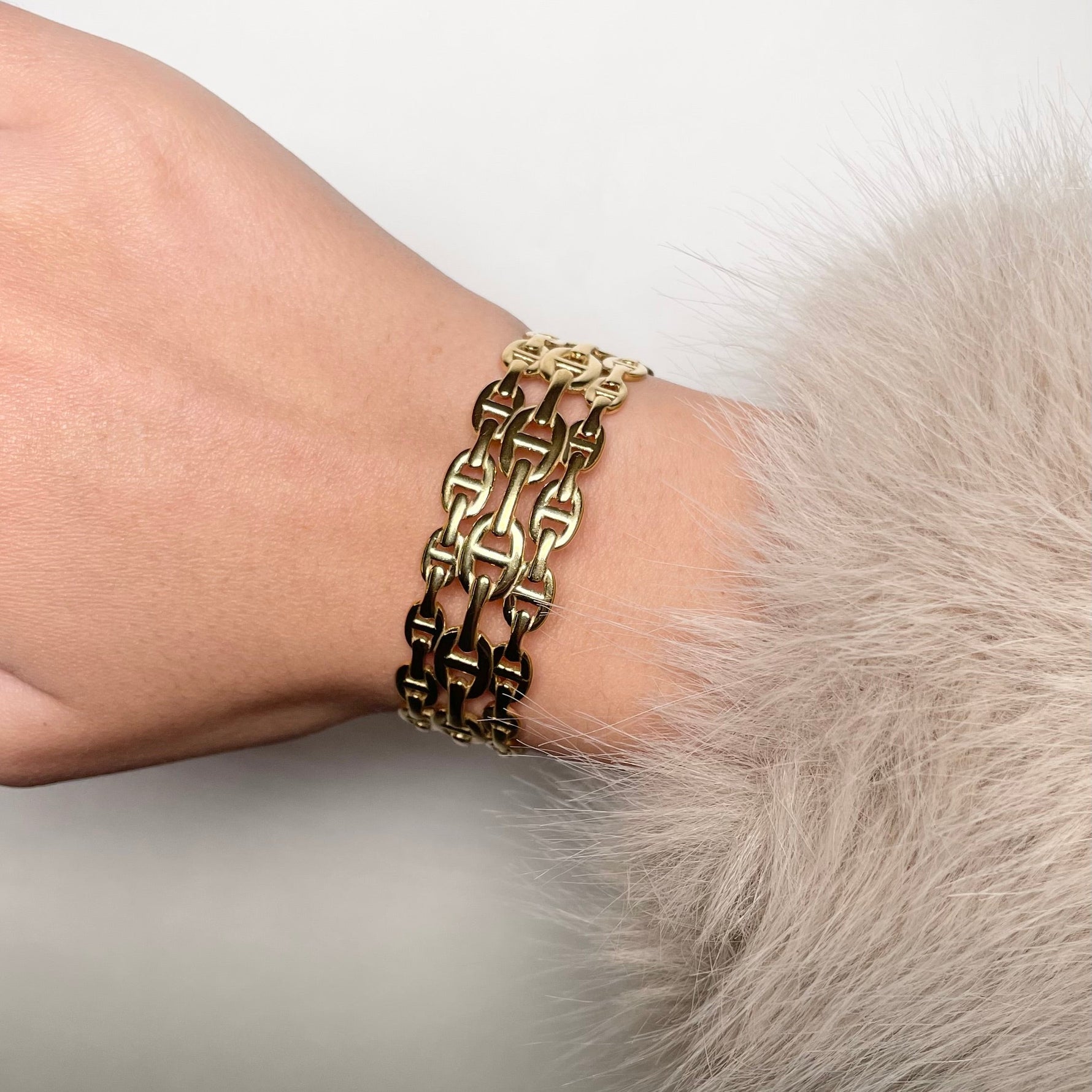 Jonc épais triple maille marine en acier inoxydable doré pour femme.