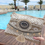 Pochette bohème en tissu dentelle blanche avec œil protecteur, pompon, coquillages et médaillon doré – pochette d'été femme à porter en bandoulière ou crossbody