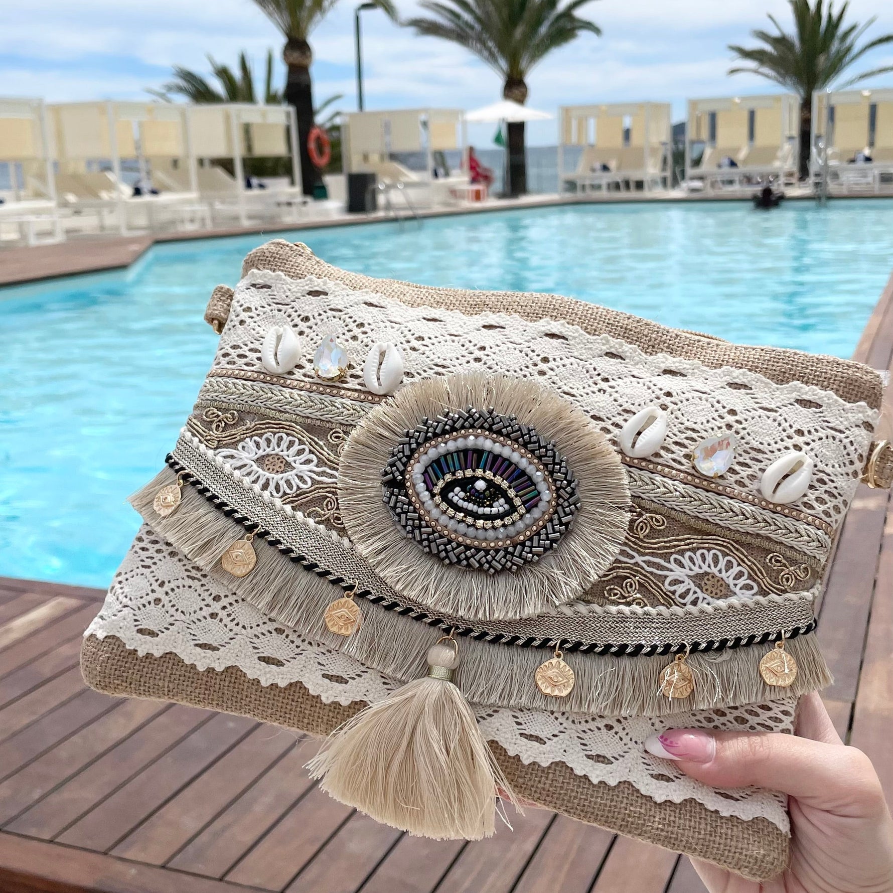 Pochette bohème en tissu dentelle blanche avec œil protecteur, pompon, coquillages et médaillon doré – pochette d'été femme à porter en bandoulière ou crossbody
